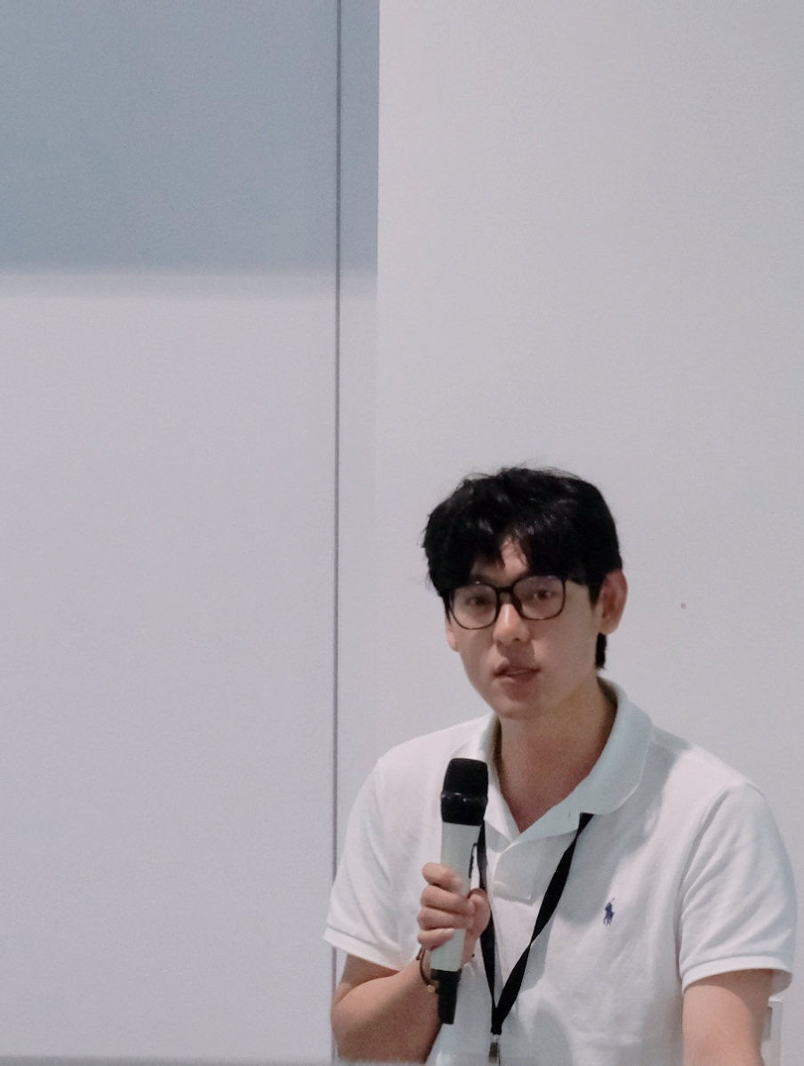 Apei Song speaking with a microphone at a presentation